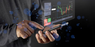 A person uses a smartphone displaying a floating digital interface with stock market charts, buy and sell buttons, and financial data against a dark background with blue light effects. | ZIIMP